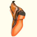 A pair of Fashion International Corso boots with premium leather and orange soles on a white background.