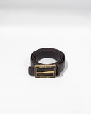 The Alta Moda Belt by ALTA features a sleek rolled-up black design with a gold rectangular buckle showcasing "Detroit" and "On the Move" against a white backdrop. Expertly crafted, this belt is proudly made in Italy, representing the pinnacle of Italian craftsmanship and style.