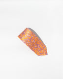 An Italian silk tie from Fashion International showcases an orange necktie with a delicate brand pattern of purple squares on a white background.