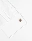 A white dress shirt cuff featuring square, silver cufflinks from Enzone on a white background.