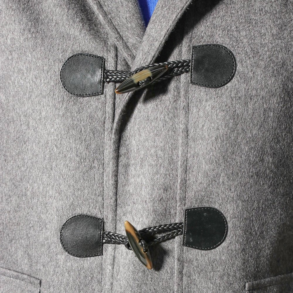 A close up of a Sartore grey duffle coat with toggle fastenings.
