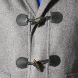 A close up of a Sartore grey duffle coat with toggle fastenings.