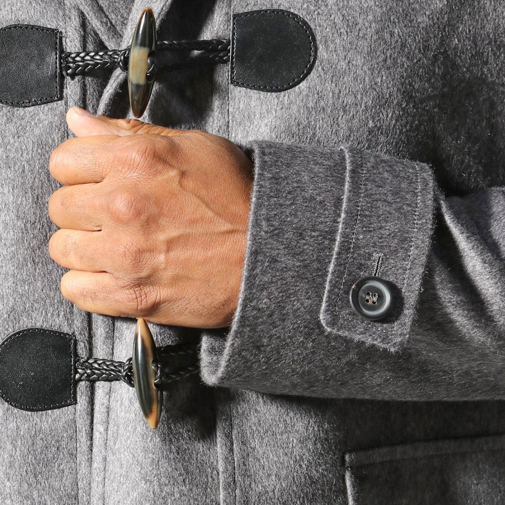 A man is wearing a trendy Sartore Italian wool duffle coat with toggle fastenings.