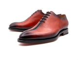 A pair of Ugo Vasare Derrick men's hand stitched oxford shoes in orange and black, made with calfskin leather.