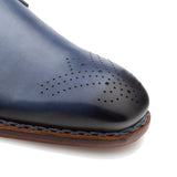 A versatile men's Mezlan Artisan Welt Monk Strap blue leather dress shoe with perforations and a buckle closure.